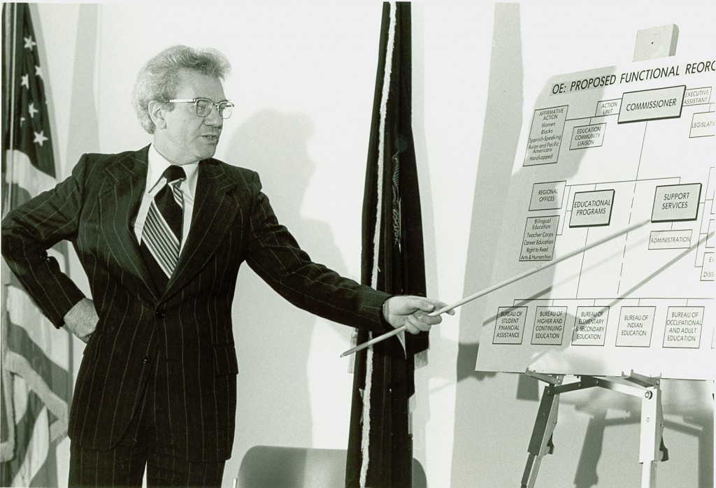 Ernest L. Boyer uses a pointer to explain a chart about new educational strategies for the federal government.