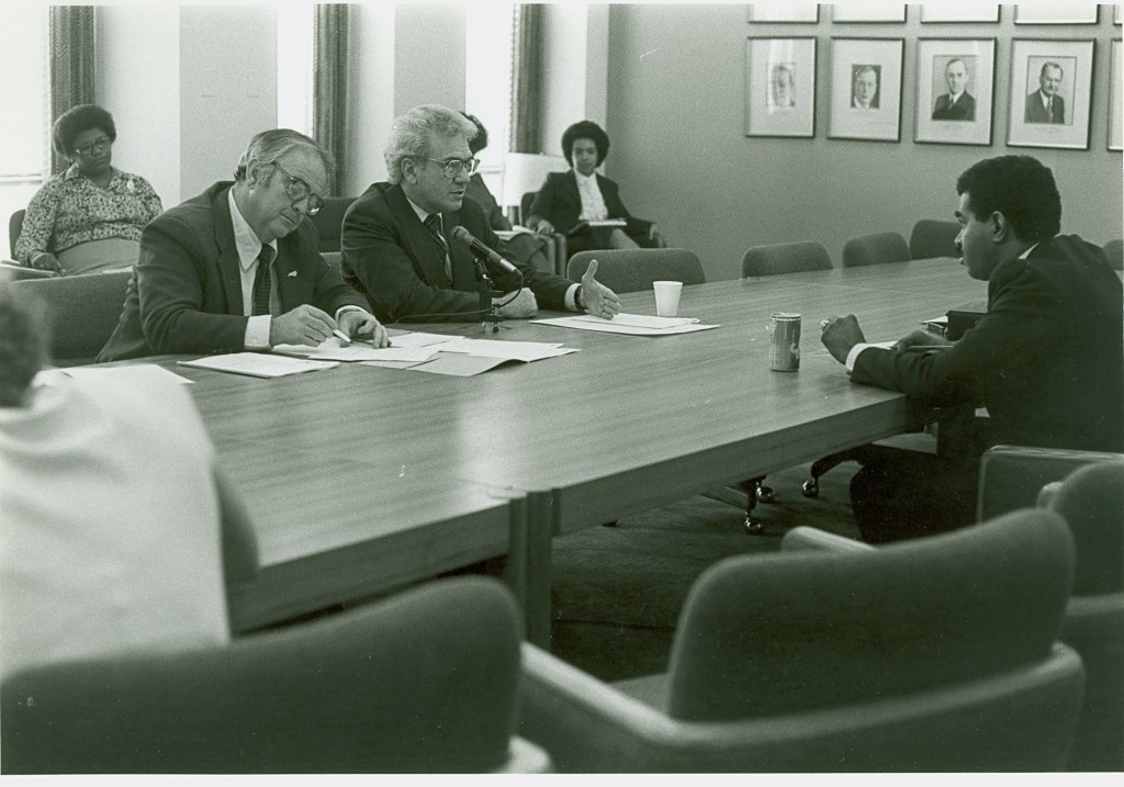 Ernest L. Boyer and other unidentified people at a board meeting in the Office of Education. - BCA