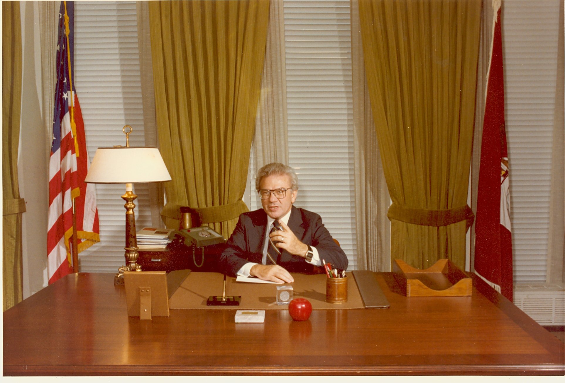 Ernest L. Boyer sitting at his desk at his welcoming party to Washington, DC as the new Commissioner of Education. - BCA