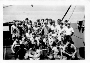 A group of young men pose for a photograph on the deck of a large ship